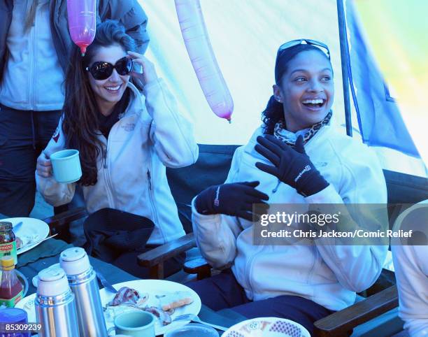 Cheryl Cole and Alesha Dixon smile as they have supper in their tent on the second day of The BT Red Nose Climb of Kilimanjaro on March 1, 2009 in...