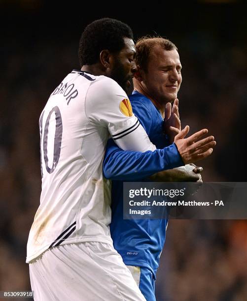 Dnipro Dnipropetrovsk's Roman Zozulya reacts after being shown a red card and is held back by Tottenham Hotspur's Emmanuel Adebayor