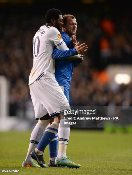 Dnipro Dnipropetrovsk's Roman Zozulya reacts after being shown a red card and is held back by Tottenham Hotspur's Emmanuel Adebayor