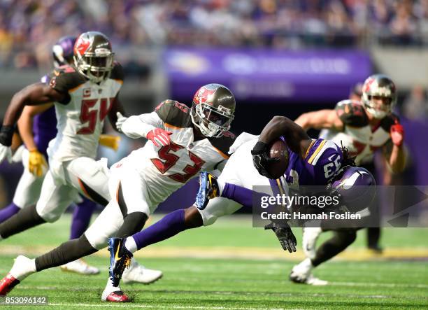 Dalvin Cook of the Minnesota Vikings is tripped up while carrying the ball in the first half of the game against the Tampa Bay Buccaneers on...