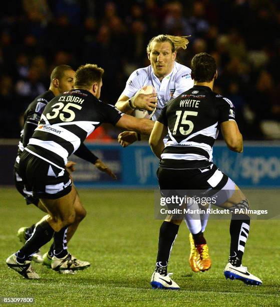 Huddersfield Giants Eorl Crabtree is tackled by Widnes Vikings Paul Clough and Lloyd White , during the First Utility Super League match at the...