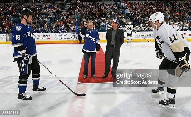 Master Champ Trevor Immelman, middle stands next to Transitions Optical President Brett Craig on the red carpet during the ceremonial puck between...