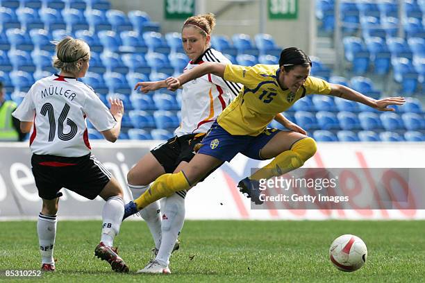 Therese Sjogran from Sweden competes for the ball with Martina Mueller and Kim Kulig during from Germany during the Women Algarve Cup match between...