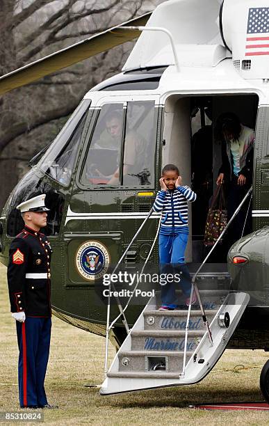 Seven-year-old Sasha Obama puts her hands over her ears as she, U.S. President Barack Obama, first lady Michelle Obama and ten-year-old Malia Obama...