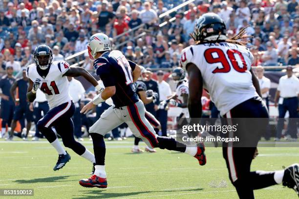 Tom Brady of the New England Patriots is pursued by Zach Cunningham and Jadeveon Clowney of the Houston Texans during the third quarter of a game at...