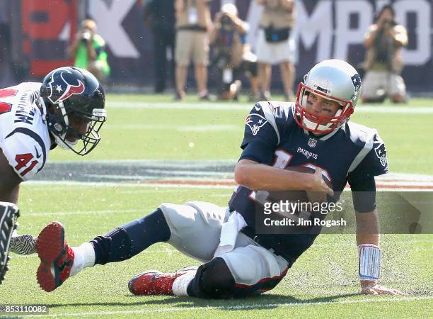 Tom Brady of the New England Patriots slides as he is tackled by Zach Cunningham of the Houston Texans during the second quarter of a game at...