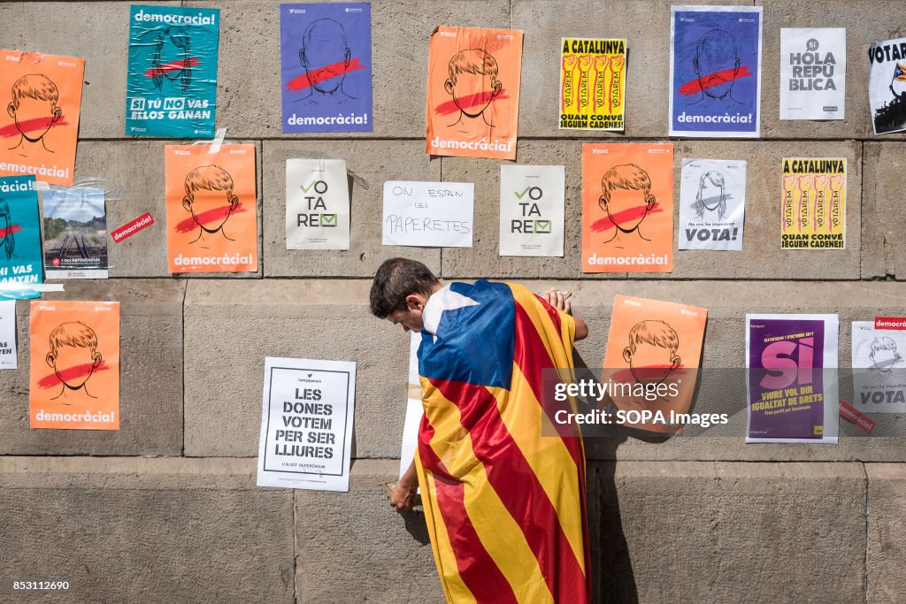 A child wearing a Catalan flag on his back, hangs several...