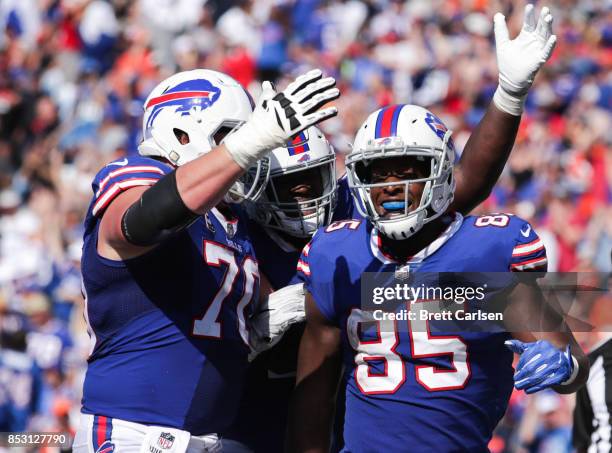 Charles Clay of the Buffalo Bills is greeted by teammates Eric Wood and Jordan Mills after Clay scored a touchdown in the second half of an NFL game...