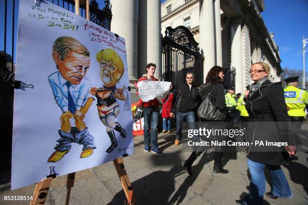 Caricature by artist Ray Sherlock is displayed as protestors await the arrival of German Chancellor Angela Merkel and Taoiseach Enda Kenny for a...