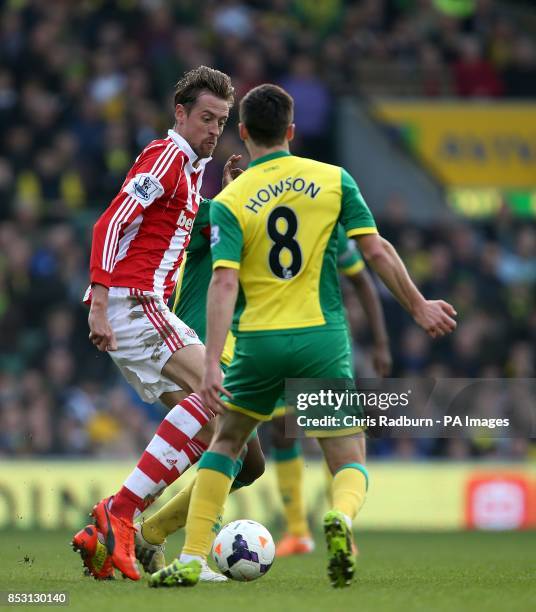 Stoke City's Peter Crouch and Norwich City's Jonathan Howson battle for the ball