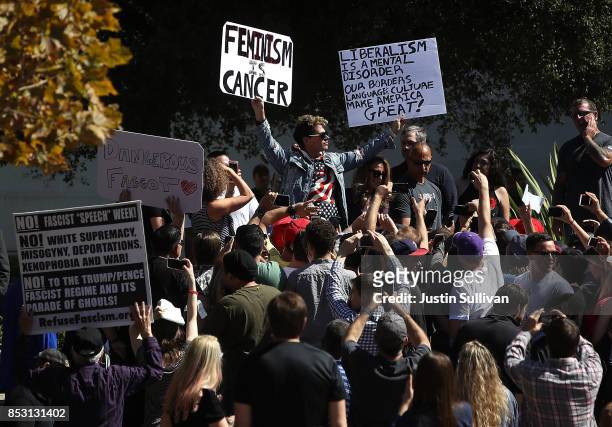 Right wing commentator Milo Yiannopoulos holds up signs as he spoke during a free speech rally at U.C. Berkeley on September 24, 2017 in Berkeley,...