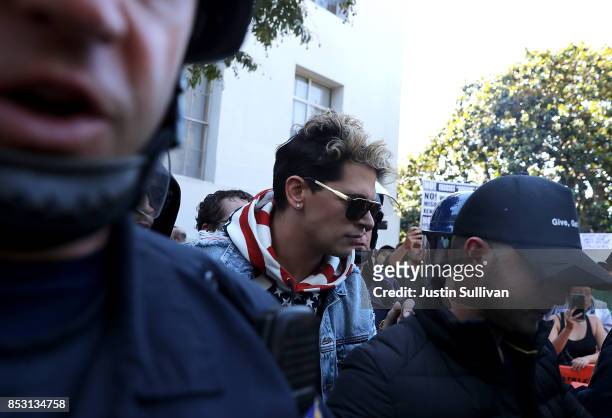 Right wing commentator Milo Yiannopoulos is escorted by police officers after he spoke during a free speech rally at U.C. Berkeley on September 24,...