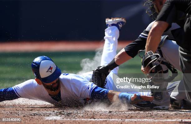 Jose Bautista of the Toronto Blue Jays is tagged out at home plate by Austin Romine of the New York Yankees in the fourth inning during MLB game...