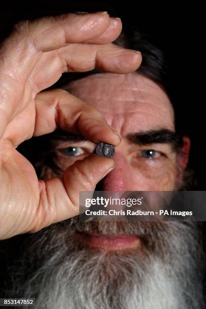 Metal-detector user Alan Smith from Diss in Norfolk, holds an Anglo Saxon coin unearthed at Sutton Hoo, along with other discoveries which include...