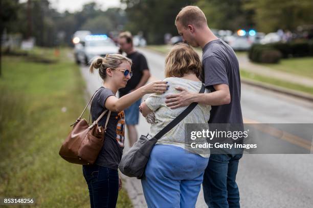 Jeff Enderson and Hailey Gilpin console people outside of the Burnette Chapel Church of Christ on September 24, 2017 in Antioch, Tennessee. One...