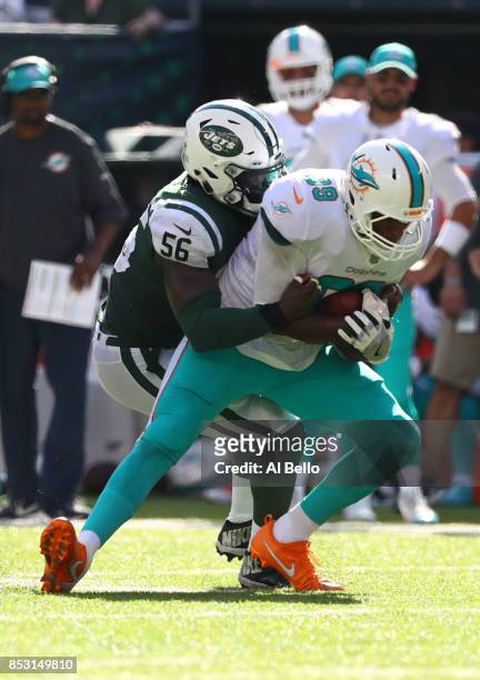 Julius Thomas of the Miami Dolphins is tackled by Demario Davis of the New York Jets during the second half of an NFL game at MetLife Stadium on...