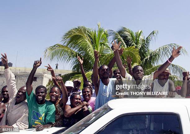 Haitans cheer as former US president Bill Clinton arrives to help distribute food in the in Cite Soleil slum of the Haitian capital Port-au-Prince...