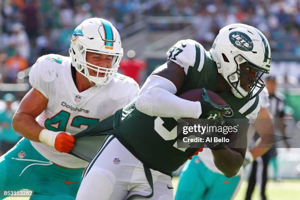 Lawrence Thomas of the New York Jets is wrapped up by Kiko Alonso of the Miami Dolphins during the second half of an NFL game at MetLife Stadium on...