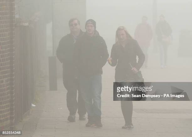 Commuters make their way in the fog to Newbury Park Underground Station, in east London, as fog covered much of the UK leading to transport problems.