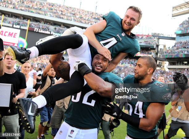 Jake Elliott of the Philadelphia Eagles is picked up by teammates Najee Goode and Kamu Grugier-Hill after Elliott kicked the game winning field goal...