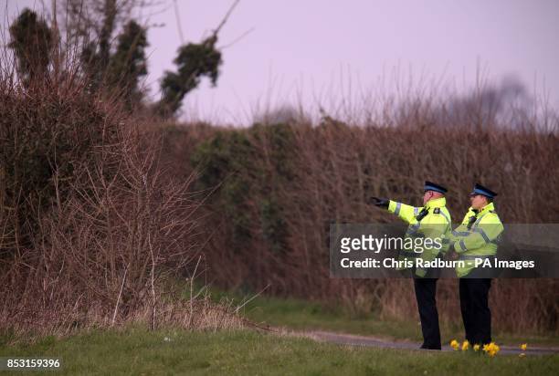 Police Officer stands in a field along the cordon line close to the A146 after four people have died when a helicopter came down in thick fog in a...
