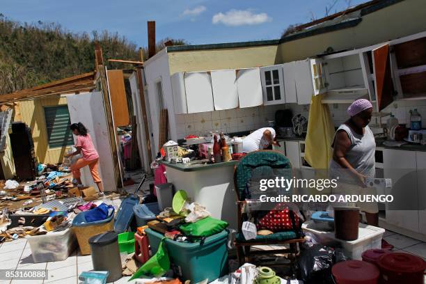 Family members collect belongings after hurricane force winds destroyed their house in Toa Baja, west of San Juan, Puerto Rico, on September 24, 2017...