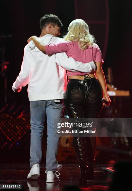 Louis Tomlinson and Bebe Rexha walk off the stage after performing during the 2017 iHeartRadio Music Festival at T-Mobile Arena on September 23, 2017...