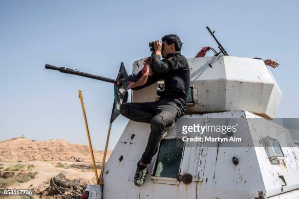 Soldier of the Hashd Al-Shaabi looks through binoculars during an offensive to drive out Islamic State militants on September 24, 2017 in Hawija,...
