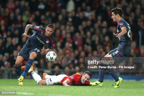 Manchester United's Robin van Persie is fouled by Olympiakos' Jose Holebas to earn his side a penalty