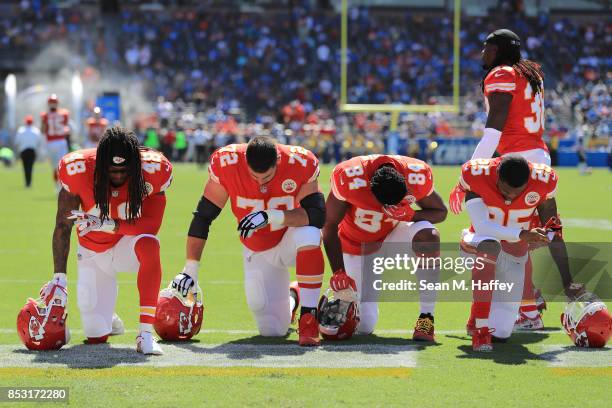 Terrance Smith, Eric Fisher, Demetrius Harris, and Cameron Erving of the Kansas City Chiefs is seen taking a knee before the game against the Los...