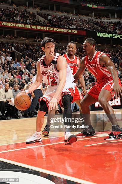 Kirk Hinrich of the Chicago Bulls drives the ball against Ron Artest of the Houston Rockets during the game at the United Center on February 28, 2009...