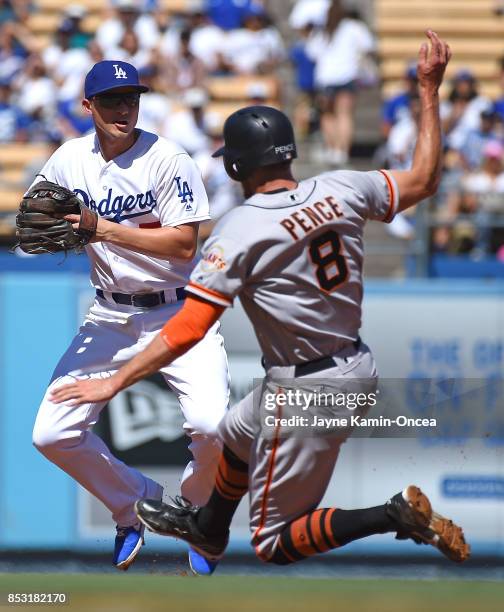 Hunter Pence of the San Francisco Giants is out on a double play as Corey Seager of the Los Angeles Dodgers throws to first to end the first inning...