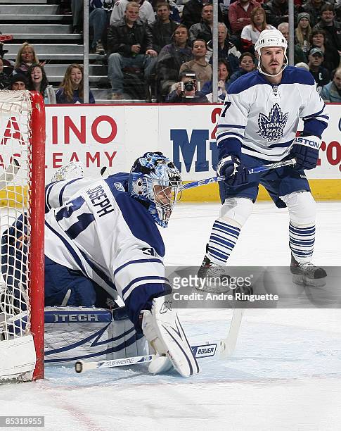 Curtis Joseph of the Toronto Maple Leafs makes a save against the Ottawa Senators as teammate Ian White looks on at Scotiabank Place on March 9, 2009...
