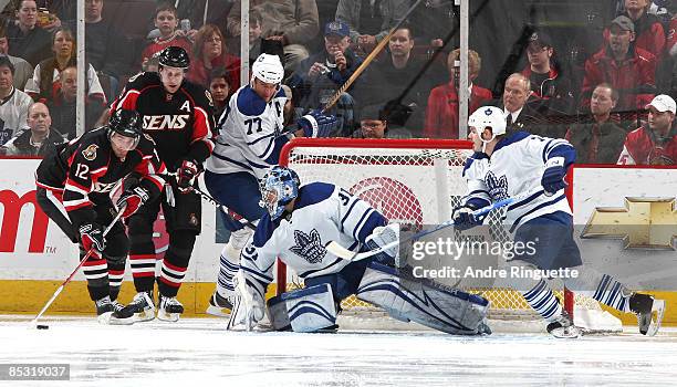 Mike Fisher of the Ottawa Senators skates the puck to the front of the net with teammate Dany Heatley as Curtis Joseph, Pavel Kubina and Ian White of...