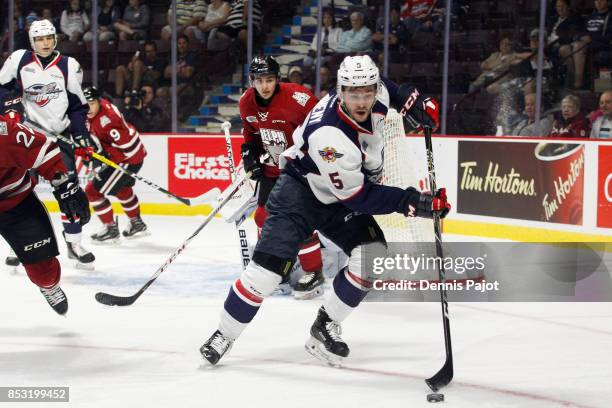 Defenceman Austin McEneny of the Windsor Spitfires moves the puck against the Guelph Storm on September 24, 2017 at the WFCU Centre in Windsor,...