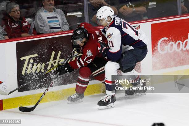Forward Cedric Ralph of the Guelph Storm moves the puck against defenceman Lev Starikov of the Windsor Spitfires on September 24, 2017 at the WFCU...