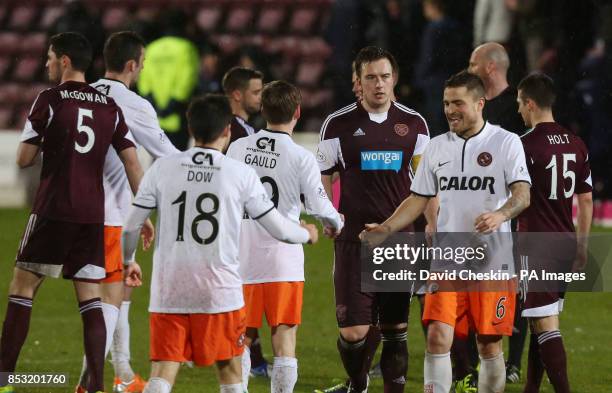 Hearts players leave the pitch dejected as Dundee United's Paul Paton , Ryan Gauld and Ryan Dow shake hands following the Scottish Premiership match...