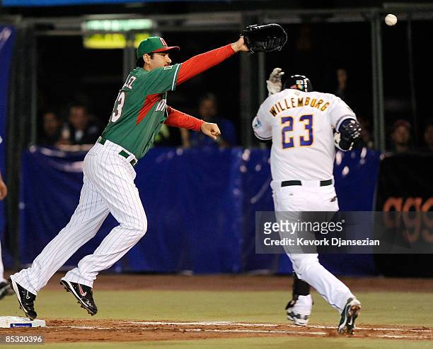 Adrian Gonzalez of Mexico stretches, but is unable to catch this errant throw from shorstop Oscar Robles as Brett Willemburg of South Africa reaches...