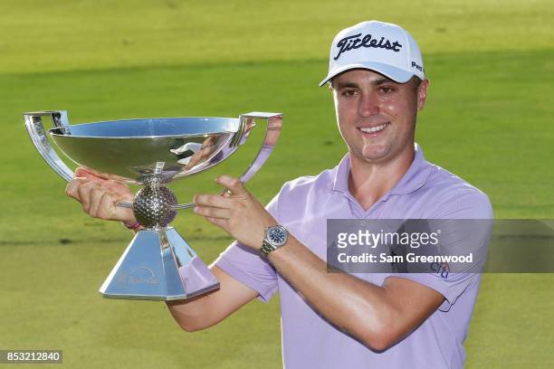Justin Thomas of the United States celebrates with the trophy on the 18th green after winning the FedExCup and second in the TOUR Championship during...