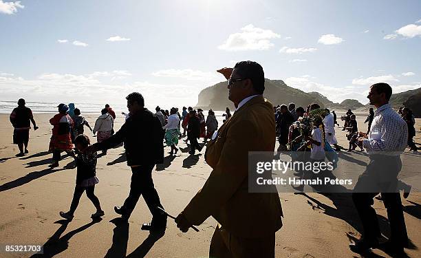 Family and friends walk towards the ocean during a memorial service for missing Warriors NRL player Sonny Fai at Bethells Beach on March 10, 2009 in...