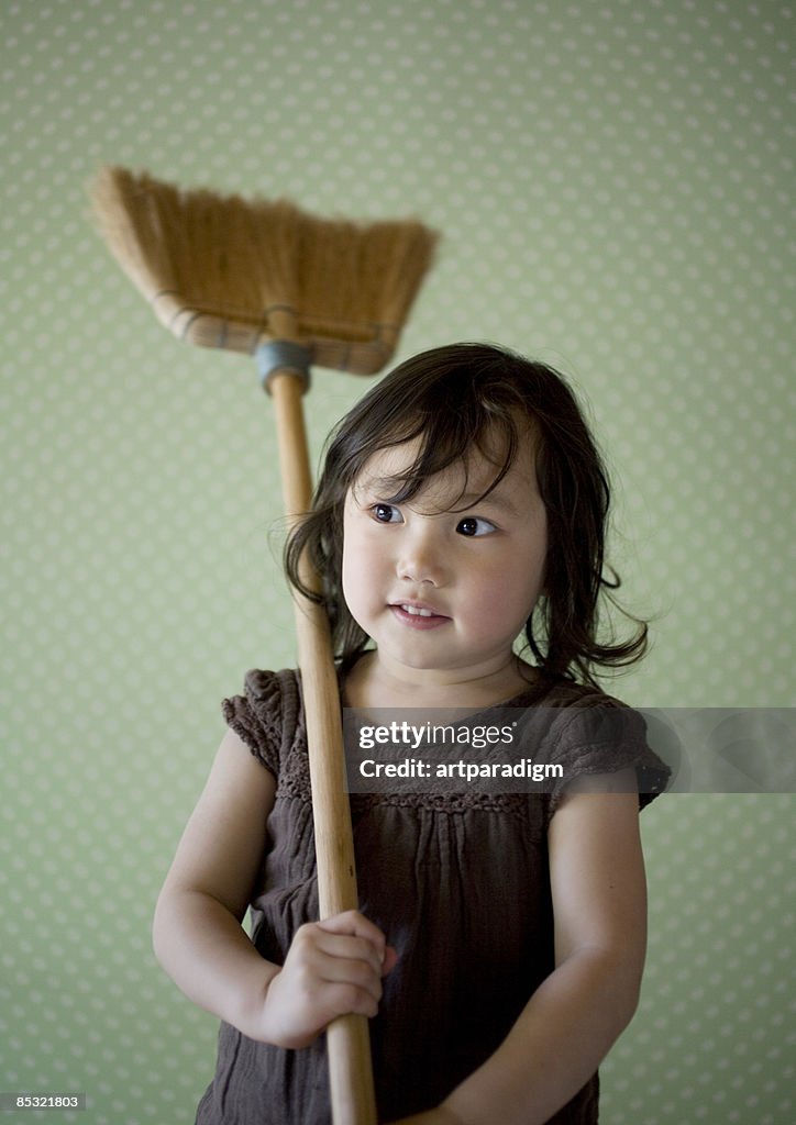 A girl playing with a broom