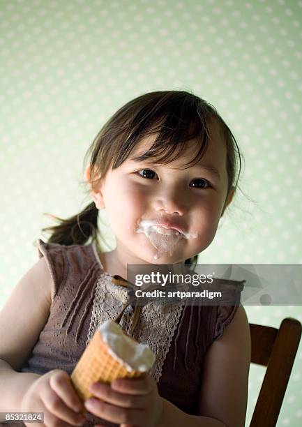 a girl eating an ice cream - girl eating messy ice cream cone stock pictures, royalty-free photos & images