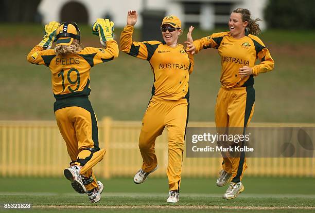 Jodie Fields, Alex Blackwell and Erin Osborne of Australia celebrate the run-out of Susan Benade of South Africa during the ICC Women's World Cup...