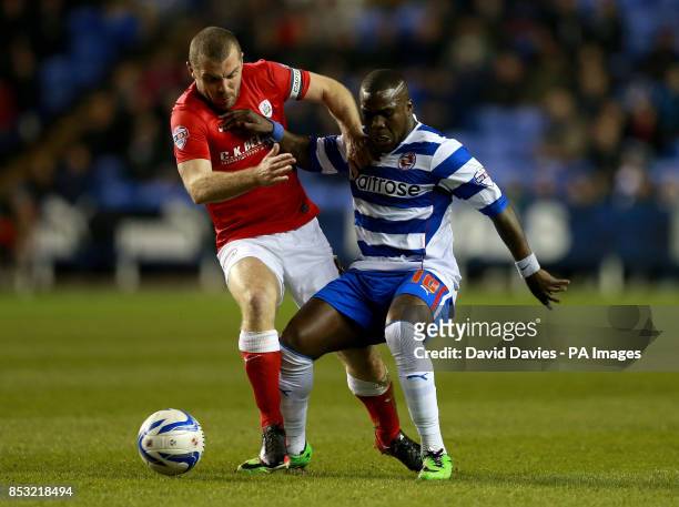 Reading's Royston Drenthe is tackled by Barnsley's Stephen Dawson during the Sky Bet Championship match at the Madejski Stadium, Reading.