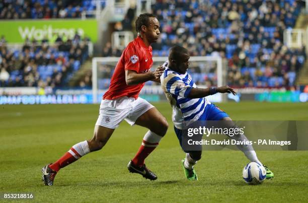 Reading's Royston Drenthe is challenged by Barnsley's Chris O'Grady during the Sky Bet Championship match at the Madejski Stadium, Reading.