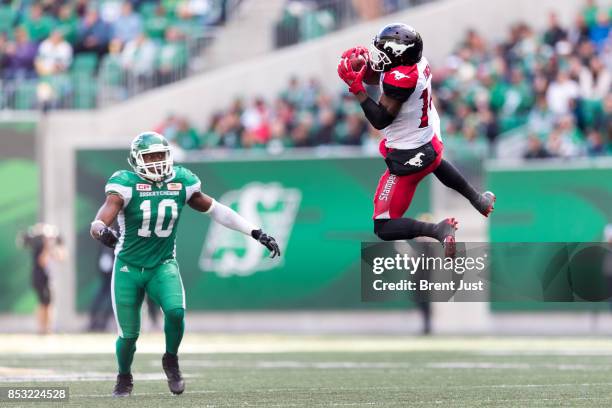 Roy Finch of the Calgary Stampeders goes high to make a catch in front of Henoc Muamba of the Saskatchewan Roughriders in the game between the...