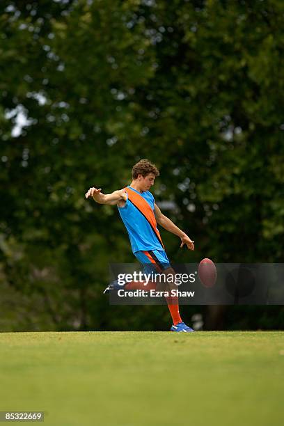 player about to kick an australian football - punt kick stock pictures, royalty-free photos & images