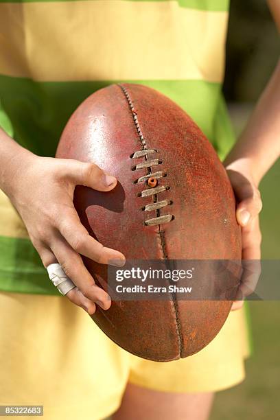 players hands holding australian football - australian rules football ball stock pictures, royalty-free photos & images