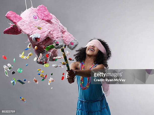 girl hitting pinata, candy flying - slam stockfoto's en -beelden