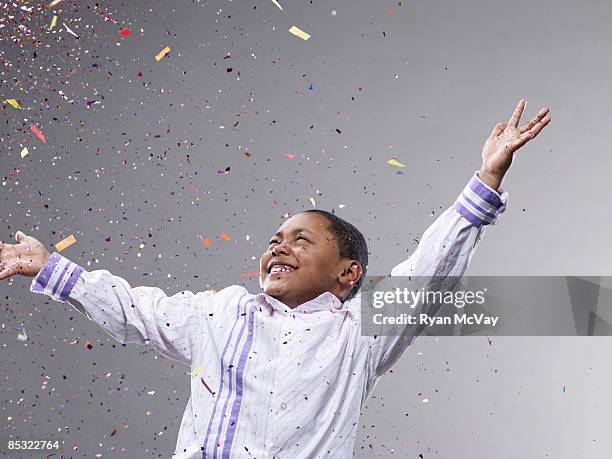 boy with hands up, confetti flying - mid air object stock pictures, royalty-free photos & images